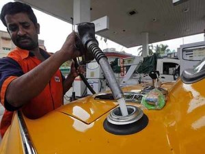 An employee fills an iconic yellow ambassador taxi with diesel at a fuel station in Kolkata